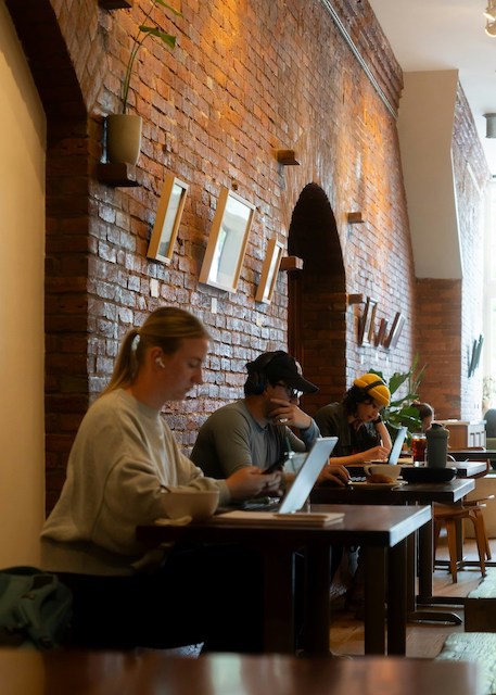 Menschen, die im gemütlichen Café an Laptops arbeiten