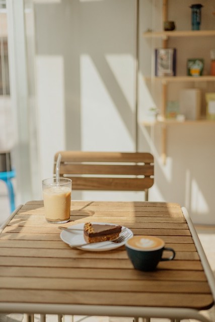 Ein Tisch mit einer Tasse Kaffee und einem Stück Kuchen darauf