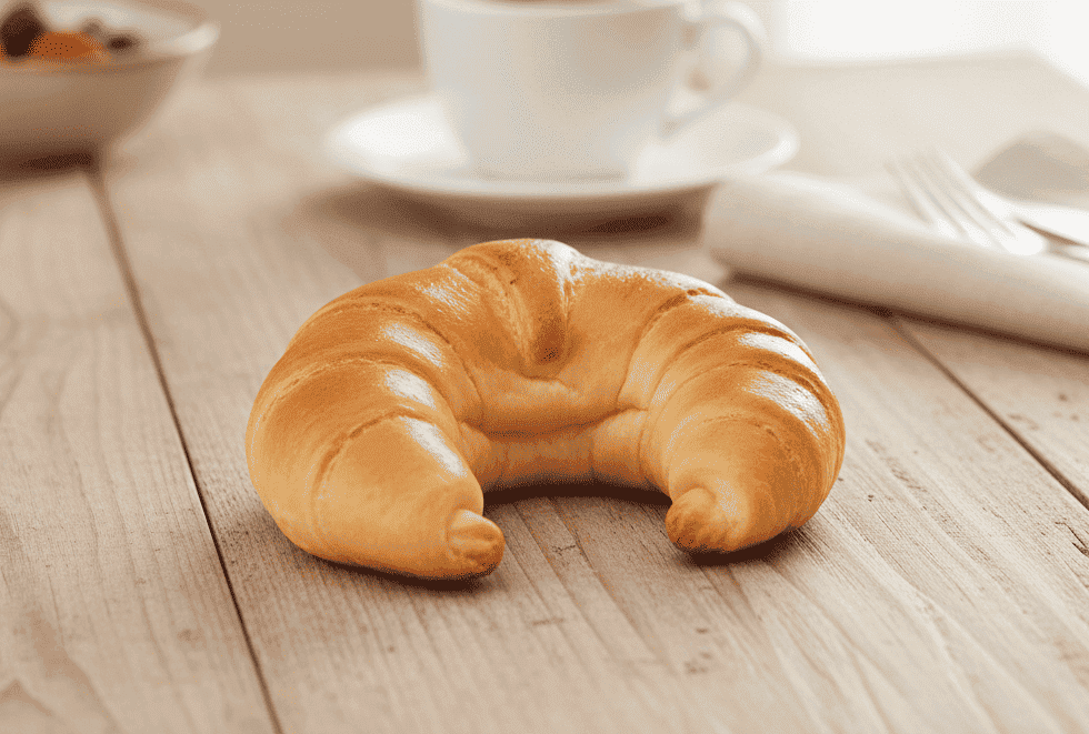 Goldbraunes Hefehörnchen auf weißem Teller